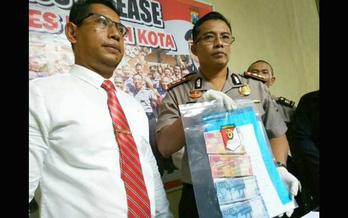 Kapolresta Kediri, AKBP Anthon Haryadi saat menunjukkan barang bukti hasil pungutan liar kepengurusan sertifikat tanah. foto: ARIF K/ BANGSAONLINE