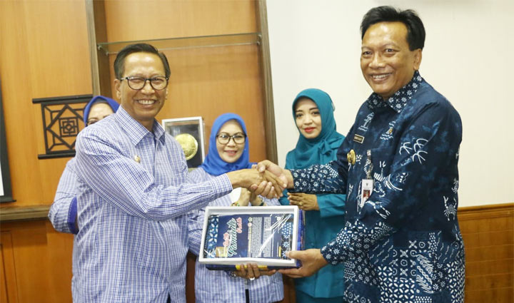 Bupati Gresik Sambari dan Wabup Polewalimandar Natsir bertukar cinderamata. foto: ist