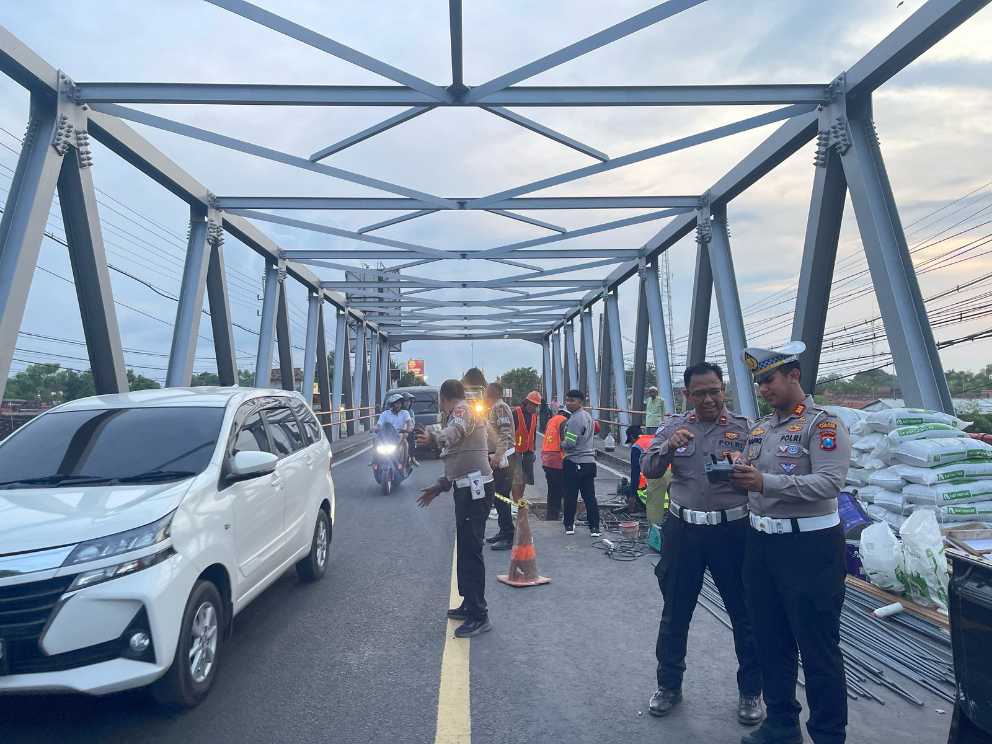 Personel Satlantas Polres Probolinggo saat mengatur kendaraan yang melewati Jembatan Pajarakan yang tengah diperbaiki