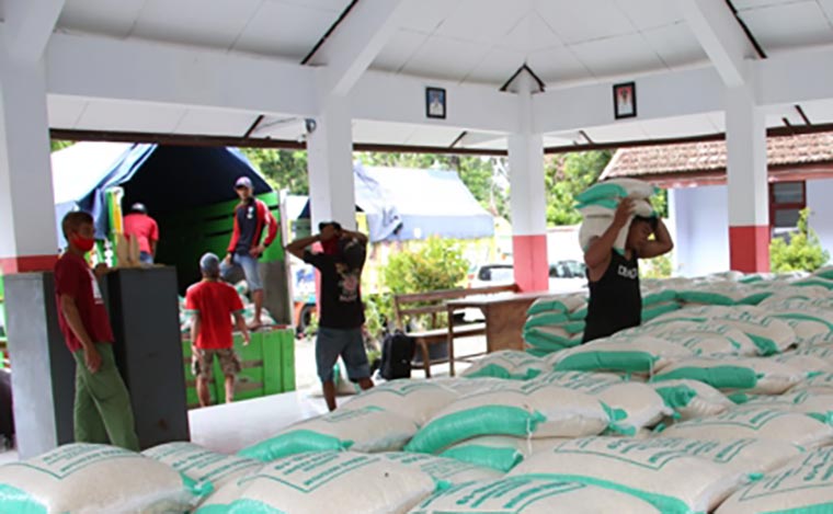 Petugas angkut saat menurunkan beras dari truk. (foto: ist.)