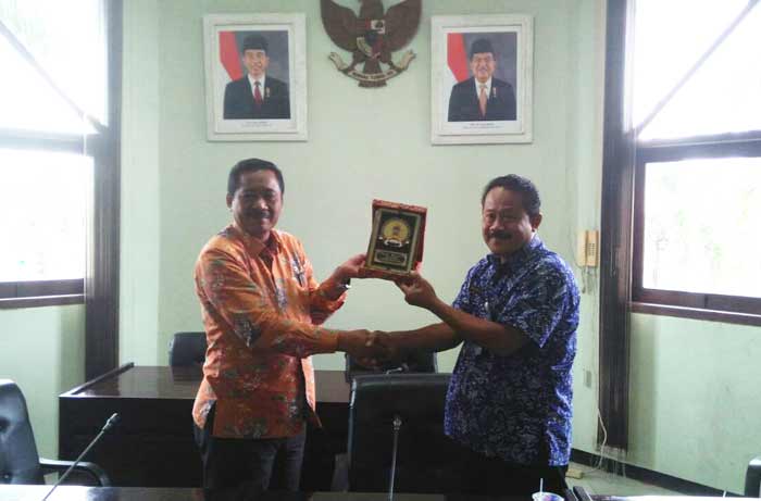 Agus Wijaya dan Ketua Komisi B DPRD Tuban bertukar cinderamata.