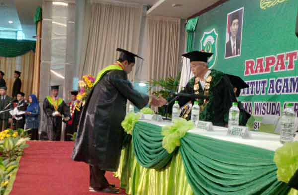 Rektor IAI Alkhoziny mewisuda salah satu mahasiswa Alkhoziny di gedung DBL Arena Jawa Pos Surabaya. (ft:yuli iksanti/BANGSAONLINE)
