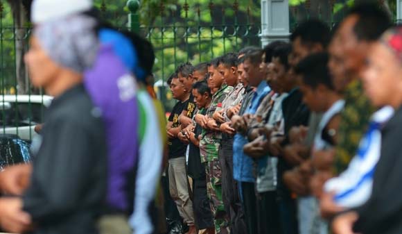 TAK LUPA: Meski dalam suasana demo, para guru tampak khusyuk melakukan salat jumlah di Lapangan Monas. Tampak aparat keamanan juga khidmat salam satu shaf (barisan). foto: merdeka.com