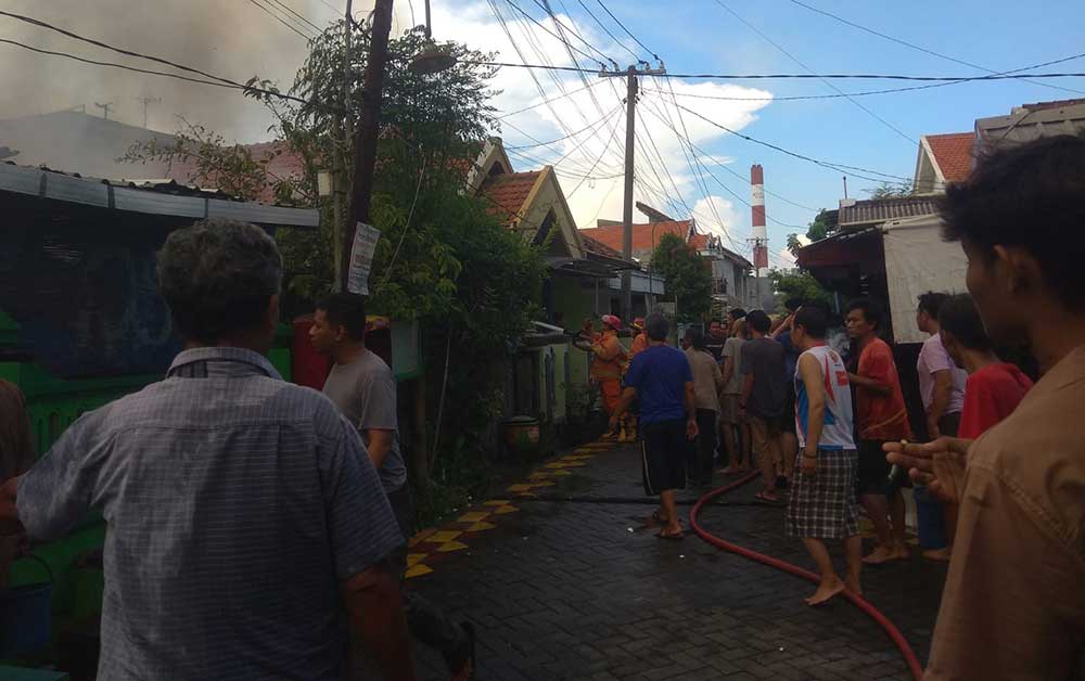 Tim Damkar Gresik dibantu warga saat memadamkan kobaran api. Foto: Ist.