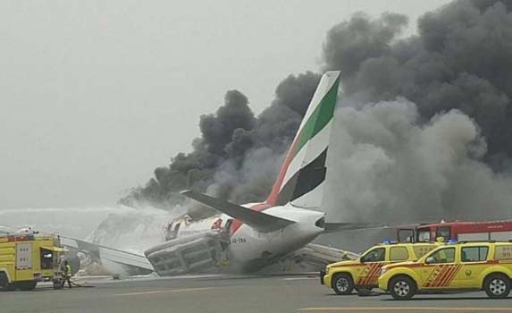 Petugas saat berusaha memadamkan api pesawat Emirates Airline. Pesawat tujuan Thiruvananthapuram, India-Dubai itu menghantam keras landasan saat mendarat hingga menyebabkan kebakaran. 