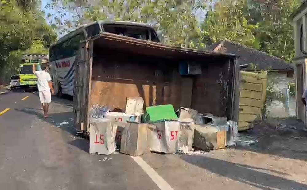 Kondisi truk yang memuat tahu terguling usai menabrak bus.
