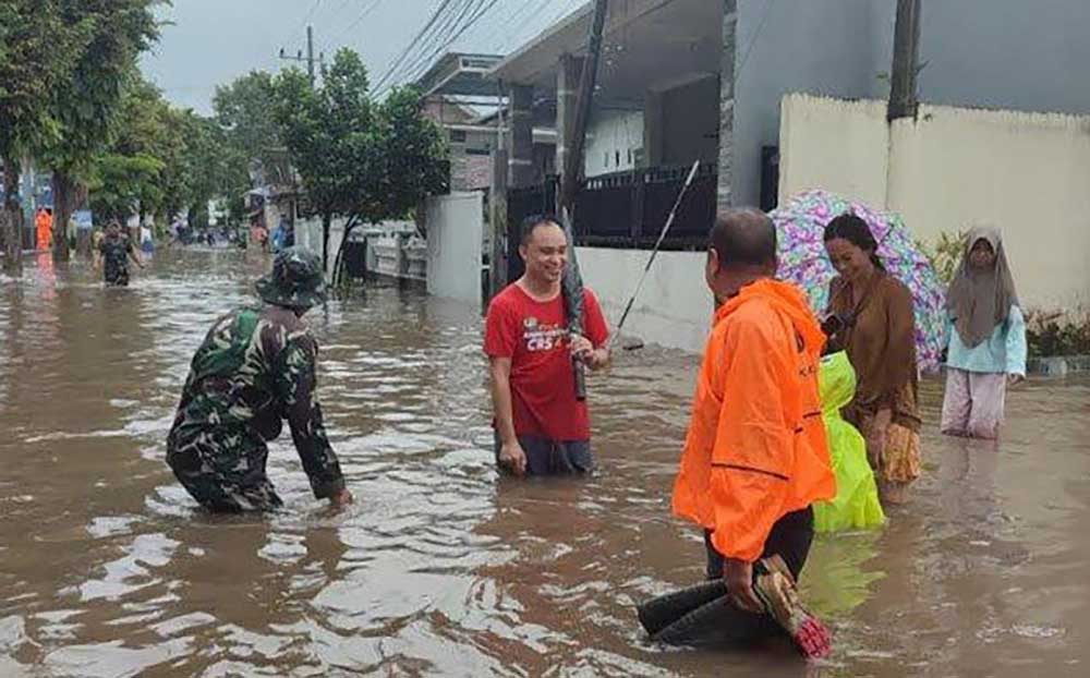 Petugas BPBD dan personel TNI saat meninjau banjir di Jalan Kaliurang Kecamatan Sumbersari Jember, Minggu (19/1/2025).