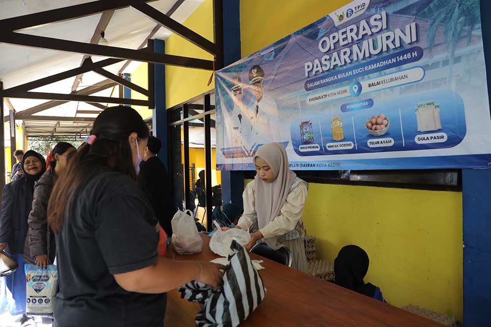 Petugas saat melayani warga yang sedang antri berbelanja. (Ist)